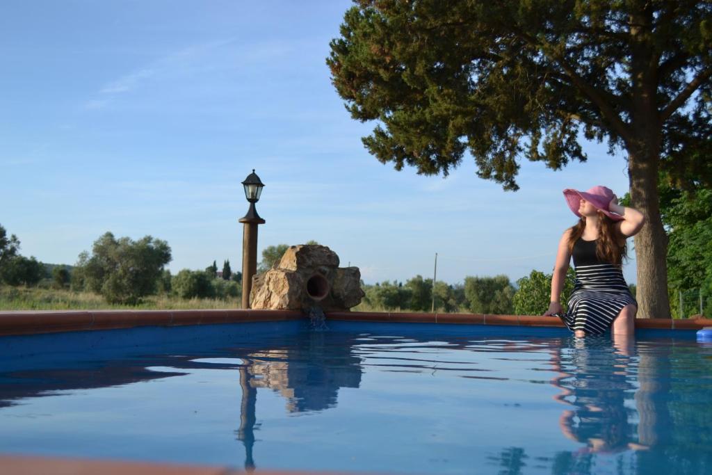 Una mujer con sombrero parada en un charco de agua en Agriturismo La Dolce Collina, en Follonica