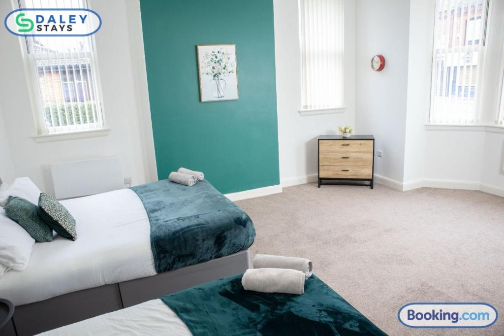 - 2 lits dans une chambre aux murs bleus dans l'établissement Failsworth large Apartment- free gated parking by Daley Stays, à Manchester