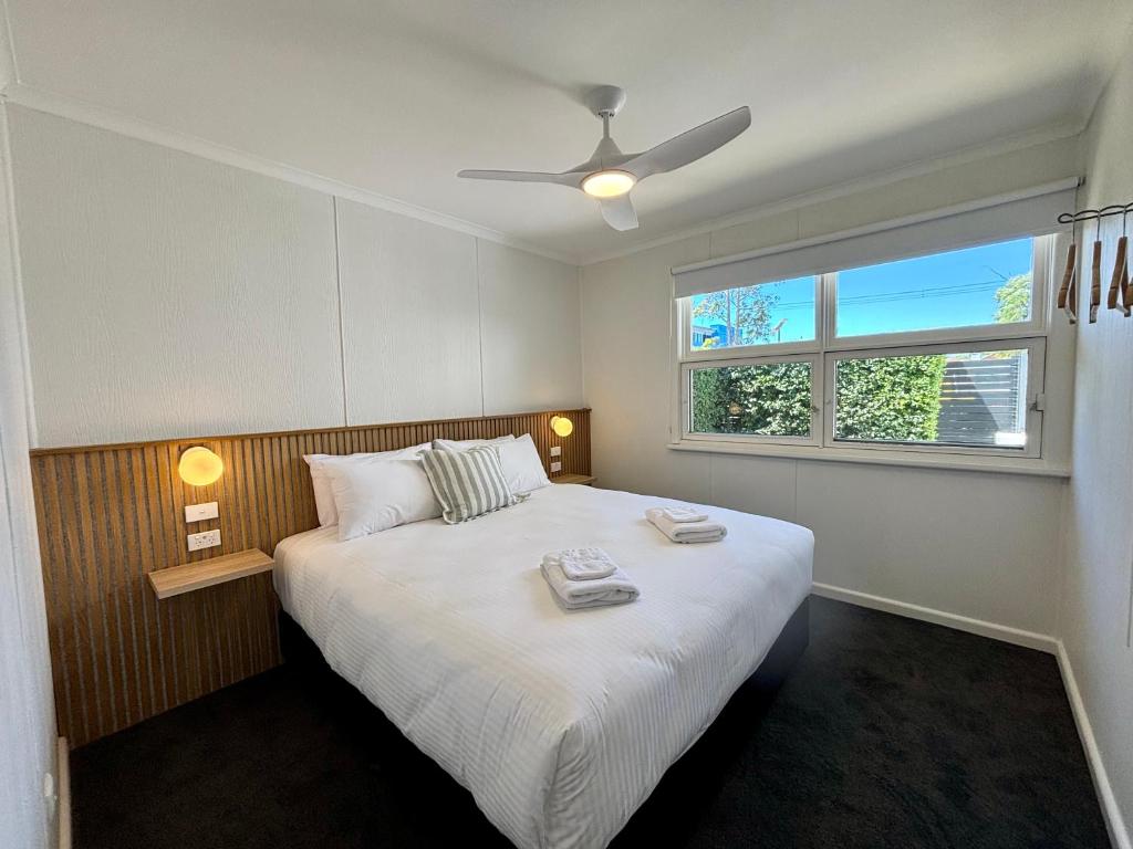 a bedroom with a large white bed with a window at High Street Motel in Echuca
