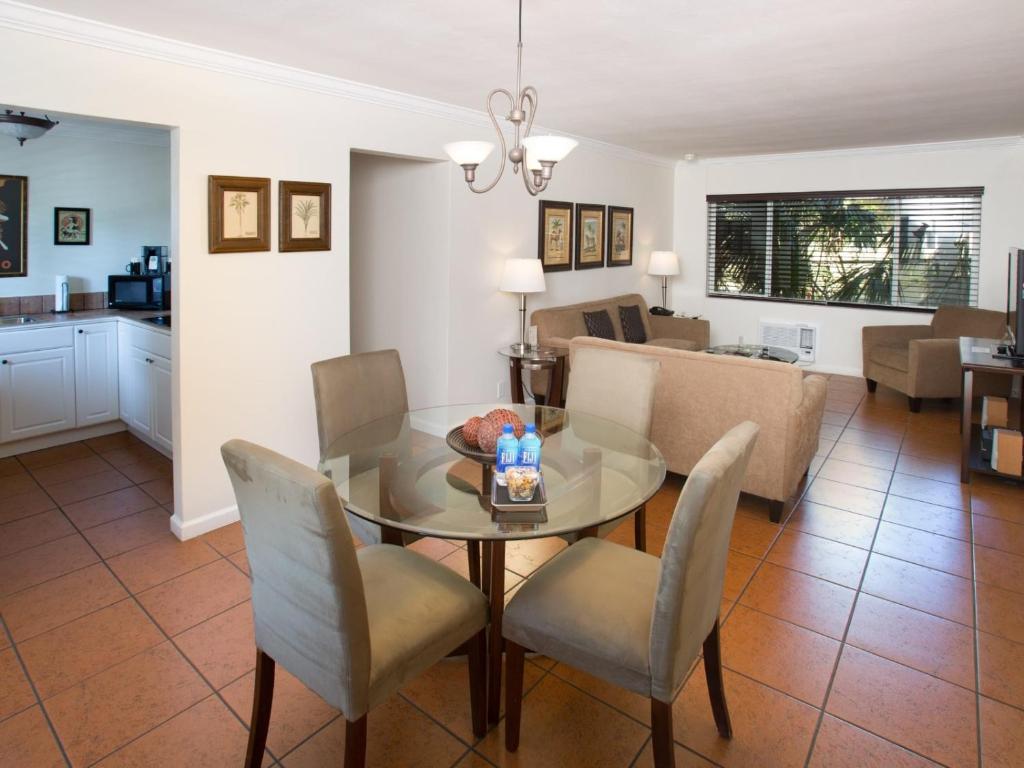 a dining room and living room with a table and chairs at The Grand Resort and Spa & Worthington All Male in Fort Lauderdale