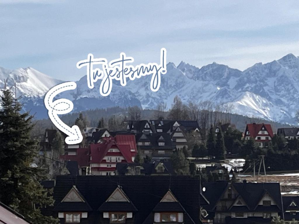 a view of a town with snow covered mountains at Na Dolinie in Bukowina Tatrzańska