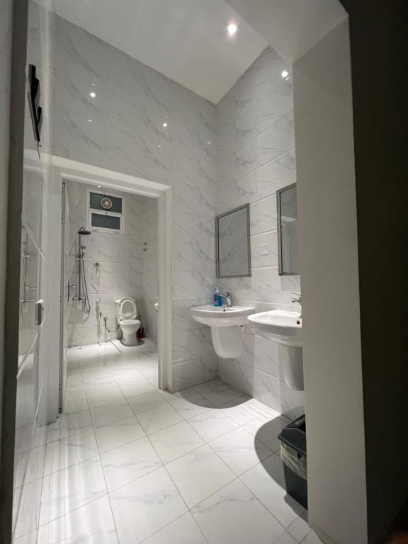 ein Badezimmer mit zwei Waschbecken, einer Dusche und einem WC in der Unterkunft ALHOULY CHALIt in Sur