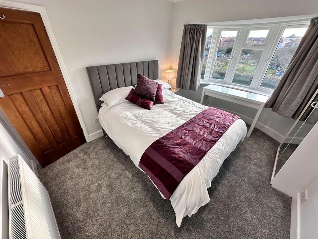 a bedroom with a bed with purple pillows on it at City centre home in Canterbury with free parking in Canterbury