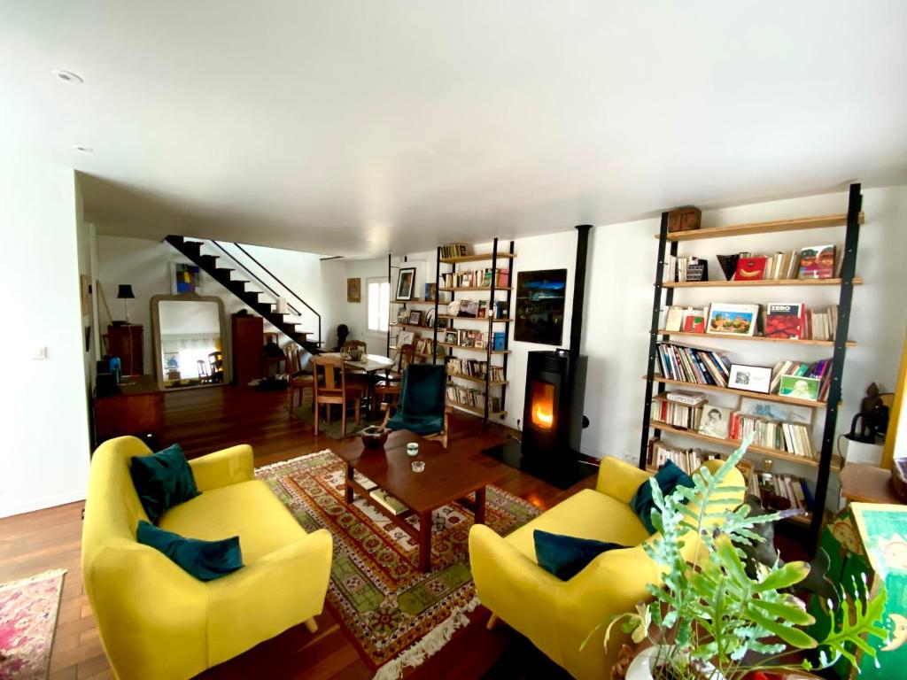 - un salon avec deux chaises jaunes et une table dans l'établissement Chez Olivier, à Montreuil