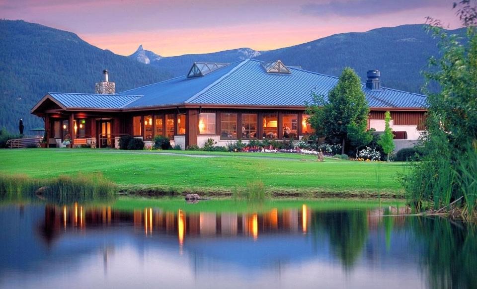 a large house with a lake in front of it at Mount Shasta Resort in Mount Shasta