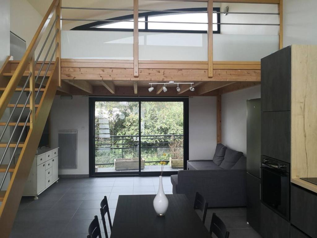 un salon avec une table et une mezzanine dans l'établissement Appartement accueillant au cœur de Le Conquet avec parking privé, au Conquet