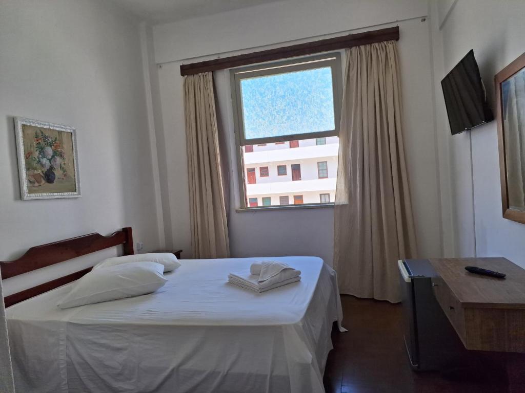 a bedroom with a bed and a large window at Grande Hotel Torres in Torres