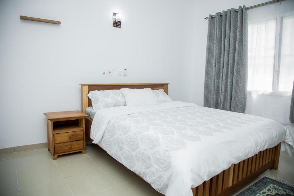 um quarto com uma cama grande e uma janela em EdenRose home em Kwabenyan