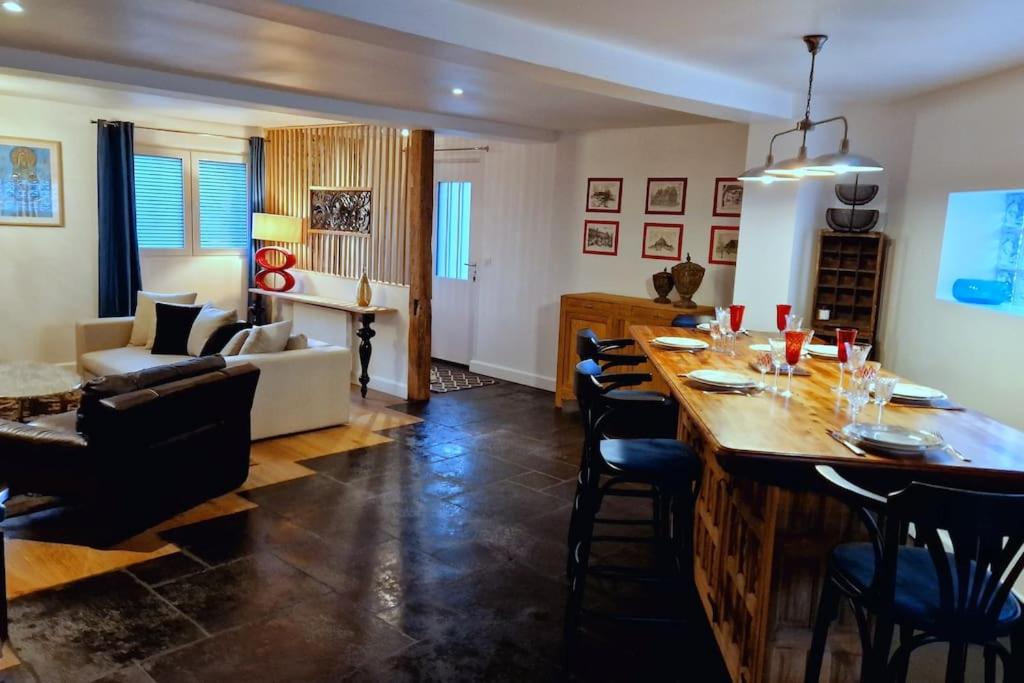 - un salon avec un grand bar en bois et des chaises dans l'établissement Le Pont Joly, à Saint-Philbert-sur-Risle