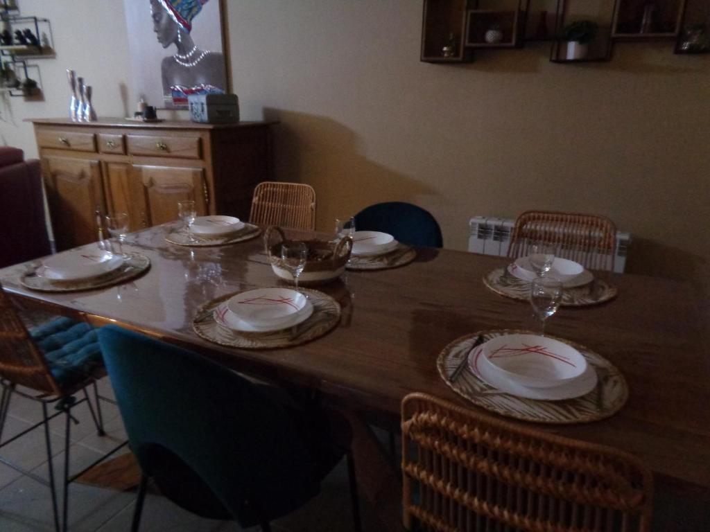 le gite de la douceur d'antan في Roquetoire: طاولة خشبية عليها لوحات واكواب للنبيذ