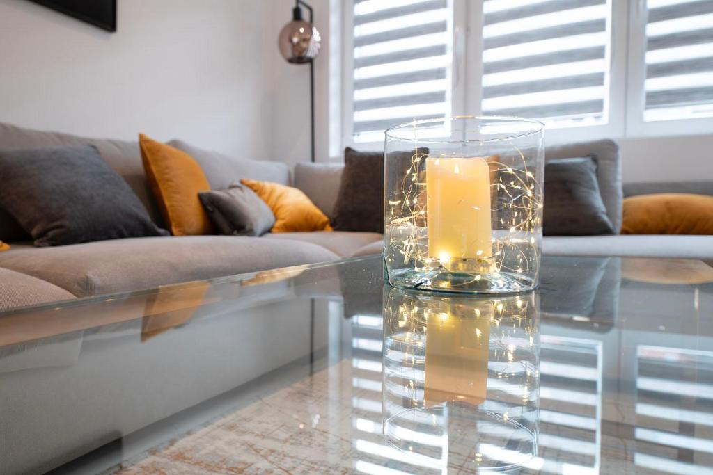 a glass vase with a candle on a glass table at LA PARENTHESE in Tournai