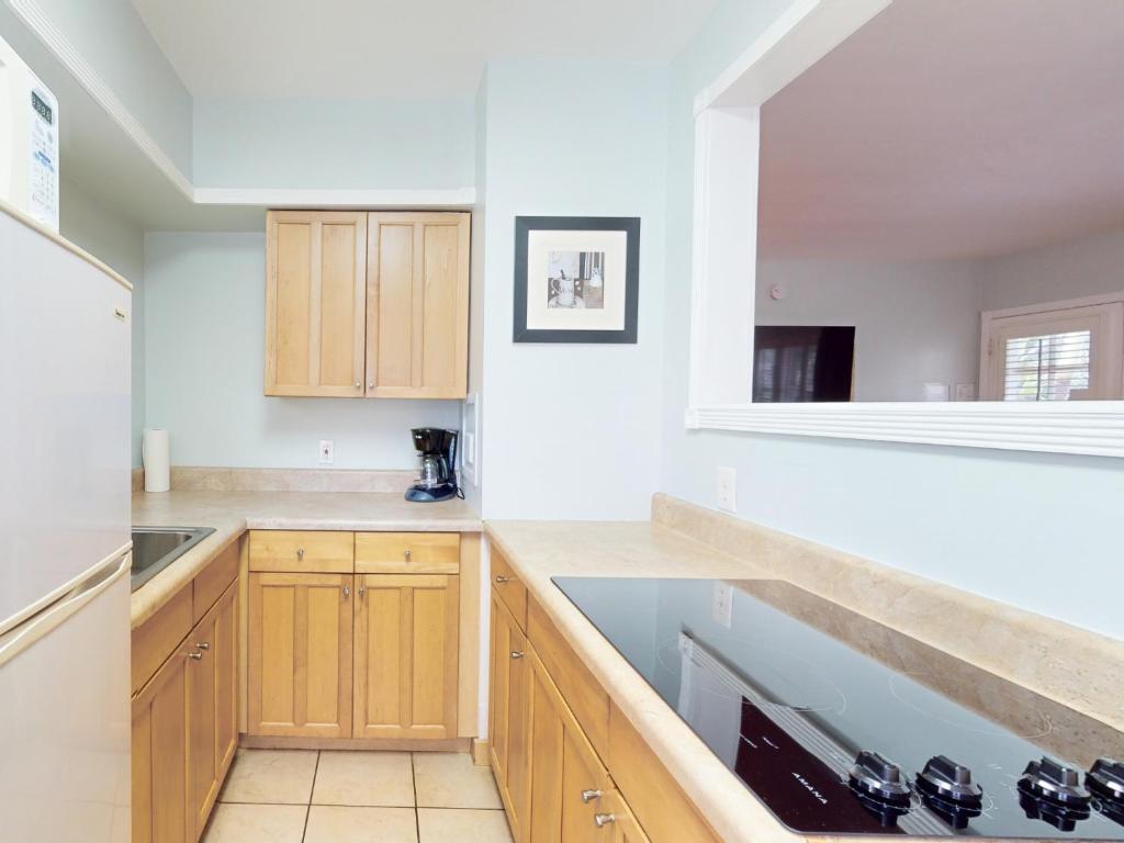 a kitchen with white walls and wooden cabinets at The Grand Resort and Spa & Worthington All Male in Fort Lauderdale