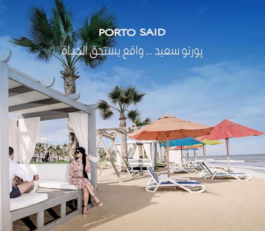 Eine Frau auf einer Bank am Strand in der Unterkunft غرفه وصاله علوى بورتو سعيد Porto Said Tourist resort in `Ezbet Shalabi el-Rûdi