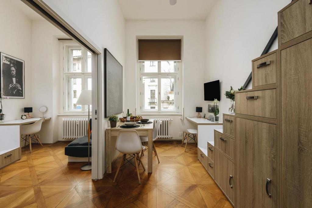 a living room with a table and a desk in it at Cozy & comfortable apt walking anywhere you want SEN in Prague