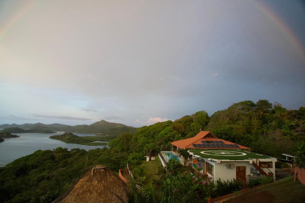 un arc-en-ciel au-dessus d'une maison sur une colline à côté d'une rivière dans l'établissement Ciel y Miel, à Colón