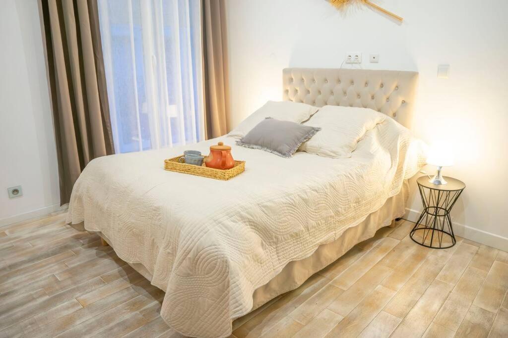 una camera da letto con un grande letto bianco con un tavolo sopra di Loft chaleureux vue directe sur le Beffroi - centre-ville secteur tribunal - wifi rétablie a Douai