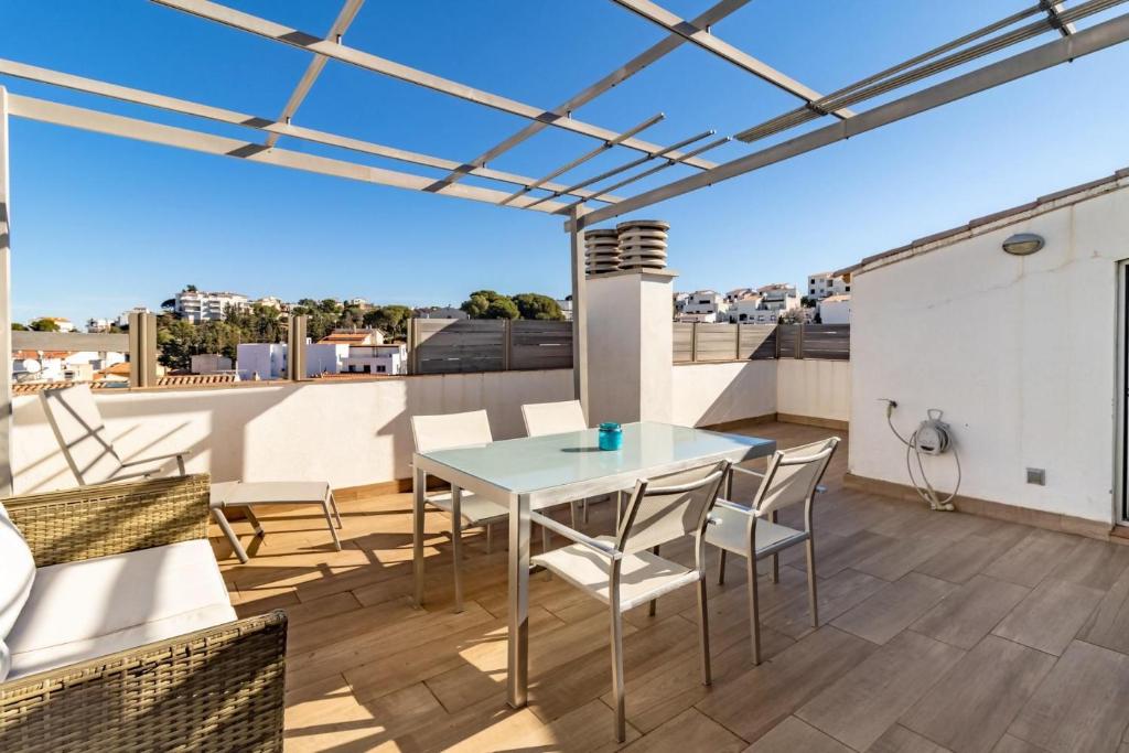 eine Terrasse mit einem Tisch und Stühlen auf dem Dach in der Unterkunft Port de Llançà 44 Apartamento moderno con terraza in Llança