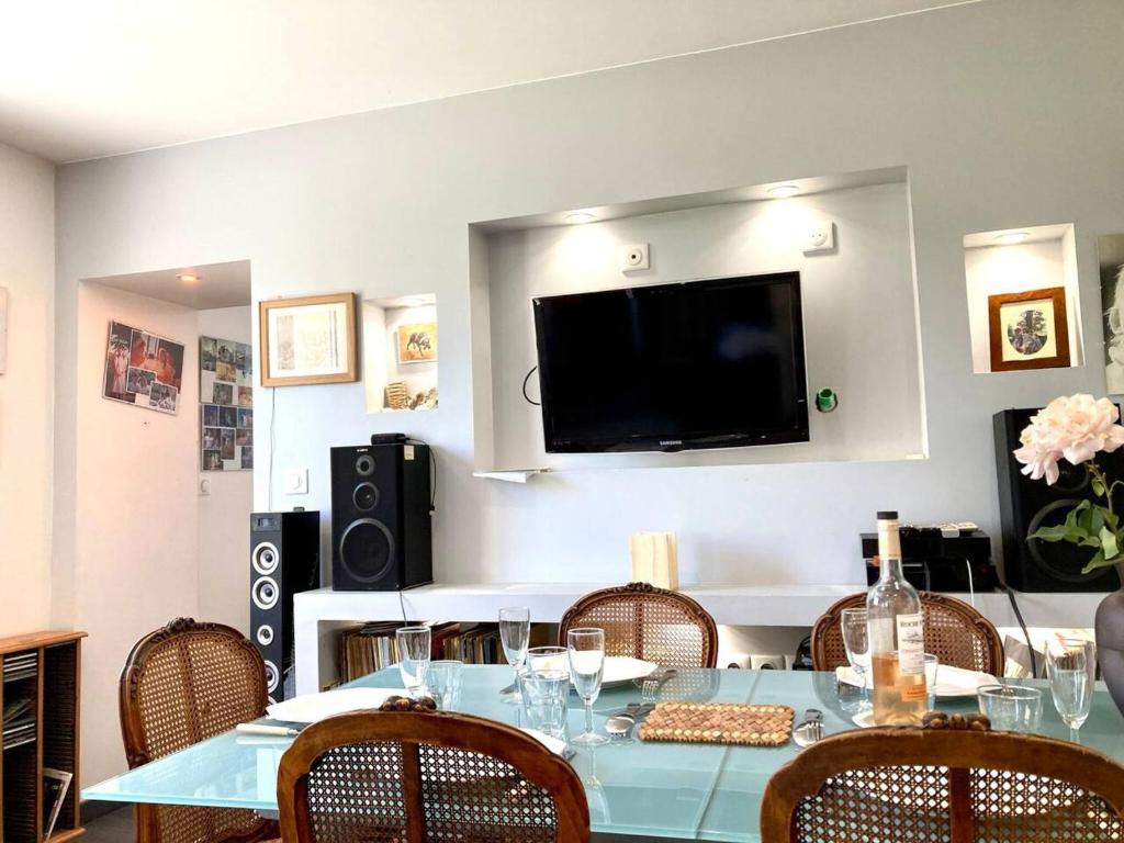 a table with chairs and a television on a wall at Propriete de 2 chambres avec terrasse et wifi a Saint Denis in Saint-Denis