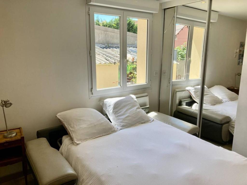 a small room with two beds and two windows at Propriete de 2 chambres avec terrasse et wifi a Saint Denis in Saint-Denis