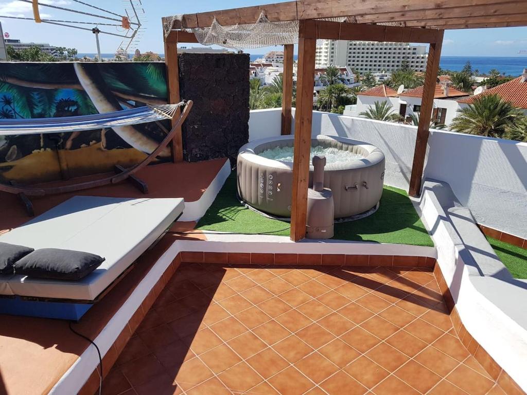 アロナにある2 bedrooms appartement at Arona 500 m away from the beach with shared pool jacuzzi and terraceのパティオ(ホットタブ、ブランコ付)