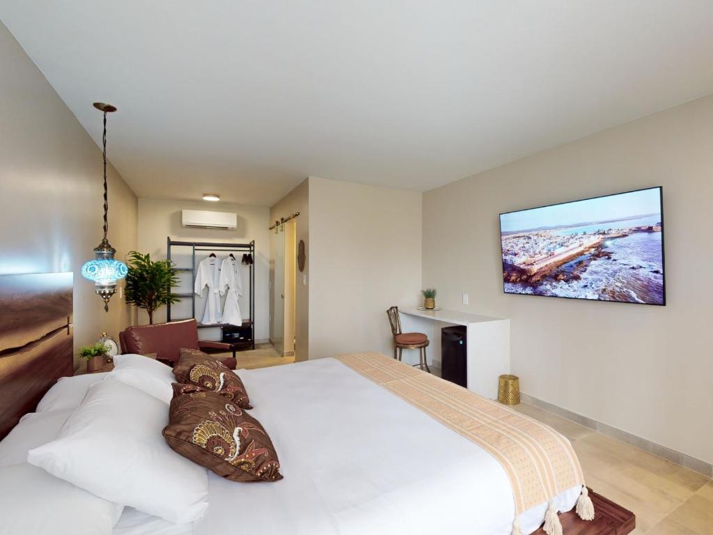 a bedroom with a white bed and a tv on the wall at The Grand Resort and Spa & Worthington All Male in Fort Lauderdale