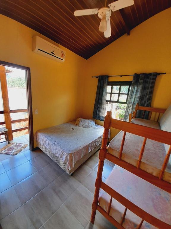 um quarto com 2 camas e uma ventoinha de tecto em Seô Hostel - Ubatuba em Ubatuba