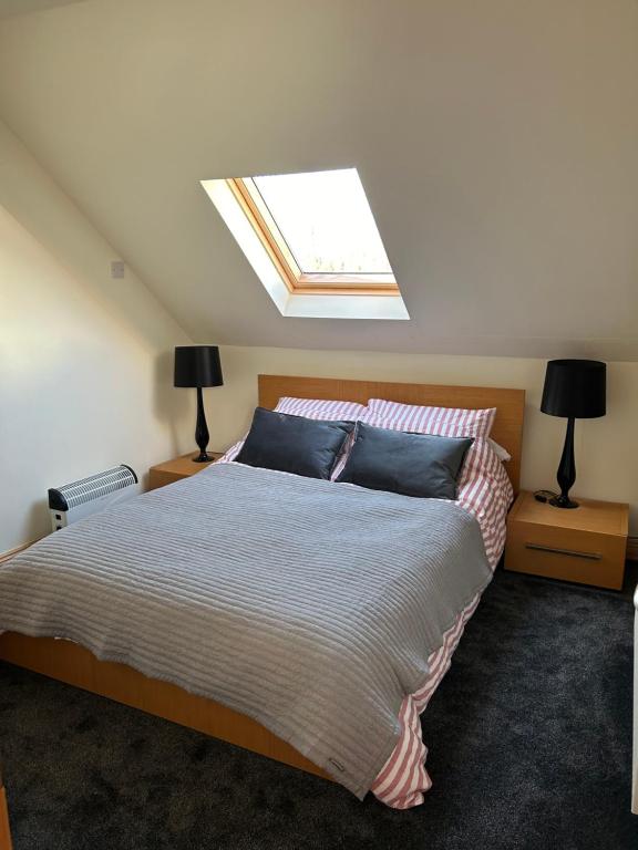 a bedroom with a large bed with a skylight at The Loft @ Kildare Village in Kildare