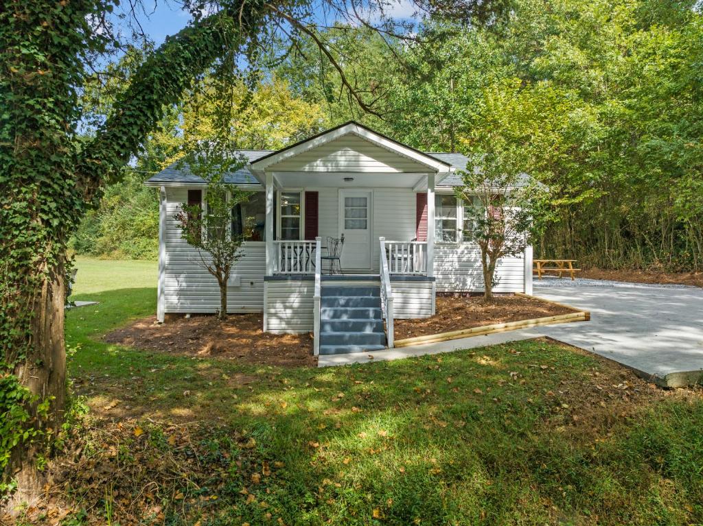a small white house with a porch and a driveway at Downtown Dahlonega Destination in Dahlonega