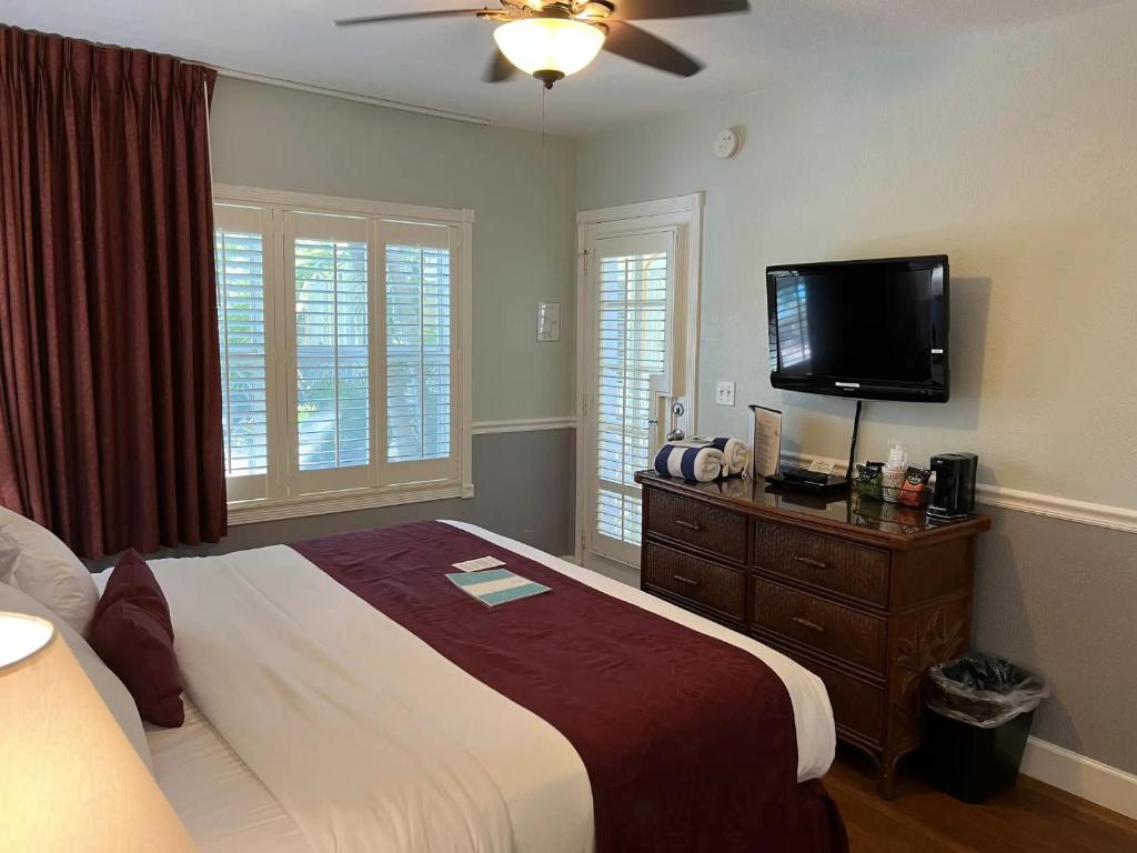 a bedroom with a large bed and a flat screen tv at The Grand Resort and Spa & Worthington All Male in Fort Lauderdale