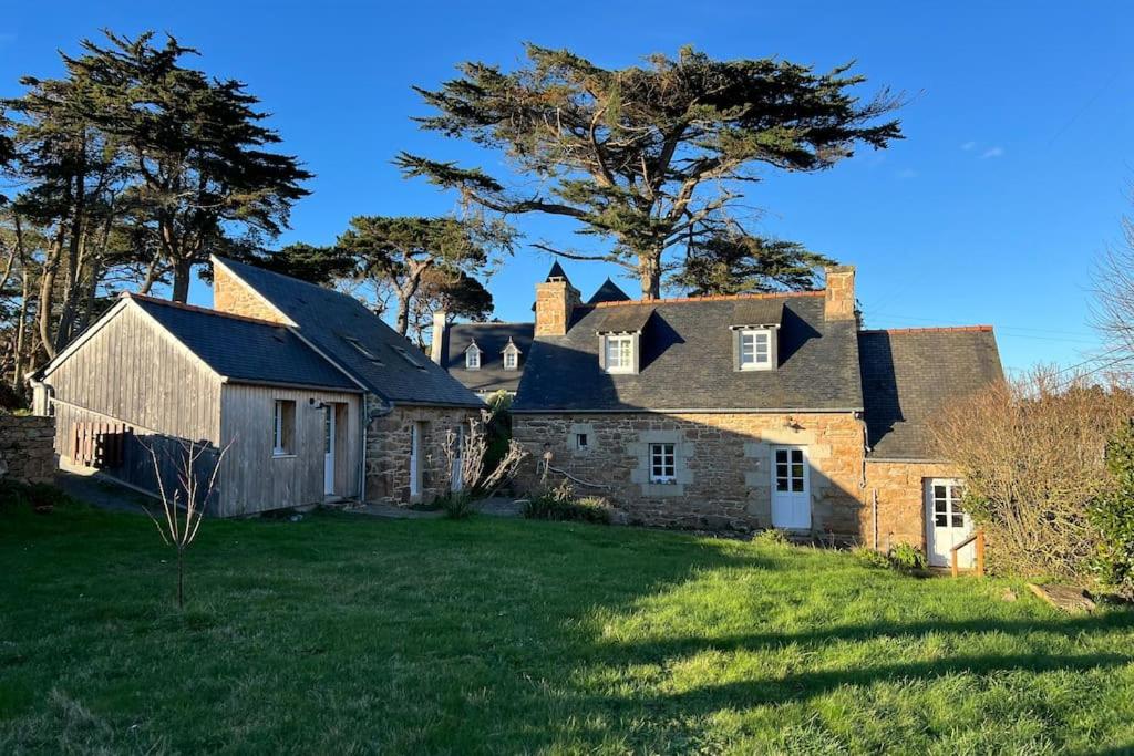 une vieille maison en pierre sur un champ herbeux dans l'établissement Charmante maison de pêcheur 6p, à pied de la mer, à Penvénan