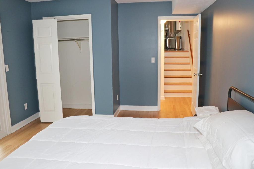 a bedroom with a white bed and blue walls at Guest house for group of 8 people in Charlottesville