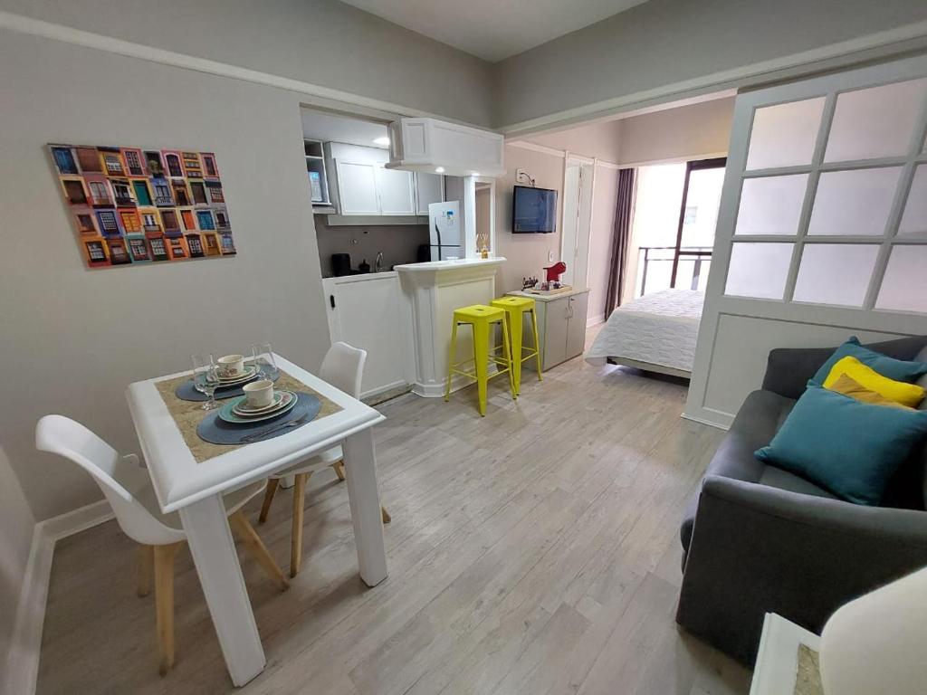 una pequeña sala de estar con mesa y sofá en Flat Champ's Elysées, en São Paulo
