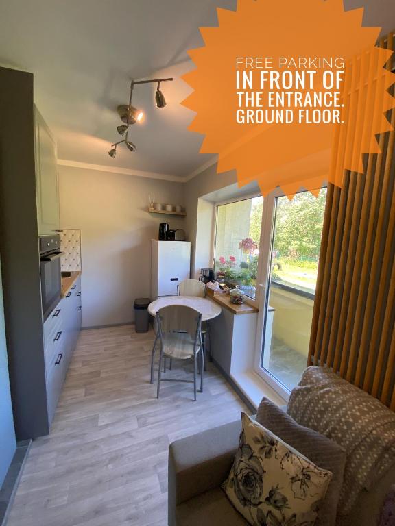 a living room with a table in front of a kitchen at Oja 134 Apartments in Pärnu