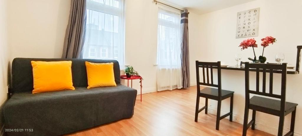 ein Wohnzimmer mit einem Sofa und einem Tisch in der Unterkunft Iris Apartment in Wembley in London