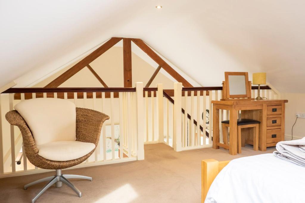 a bedroom with a bed and a chair and a desk at Grange Farm Cottages, Wressle in Selby