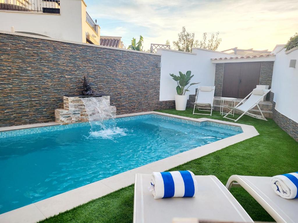una piscina con una fuente en un patio en Palmito Luxury La Torre Golf Resort Murcia, en Roldán