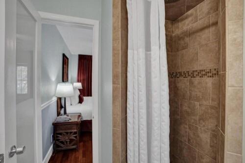 a bathroom with a shower and a room with a bedroom at The Grand Resort and Spa & Worthington All Male in Fort Lauderdale