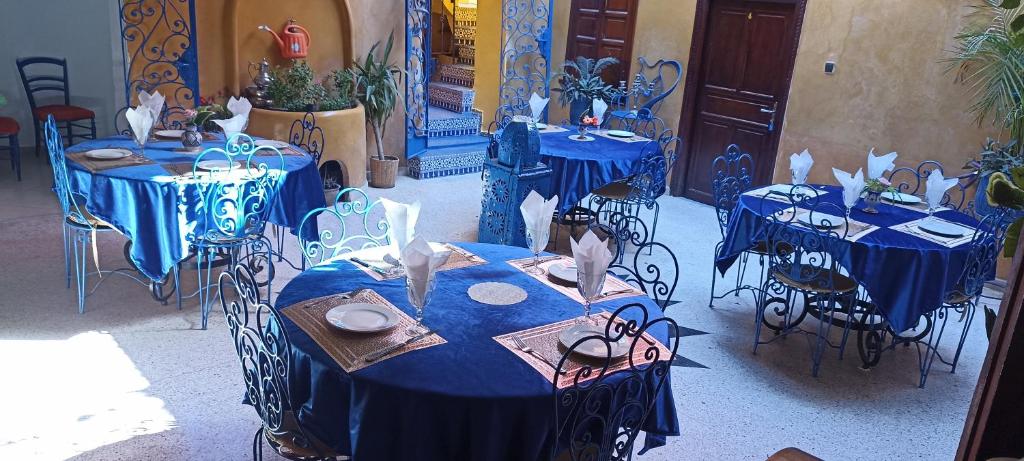 un grupo de mesas con manteles azules en Riad Le Lieu, en Tiznit