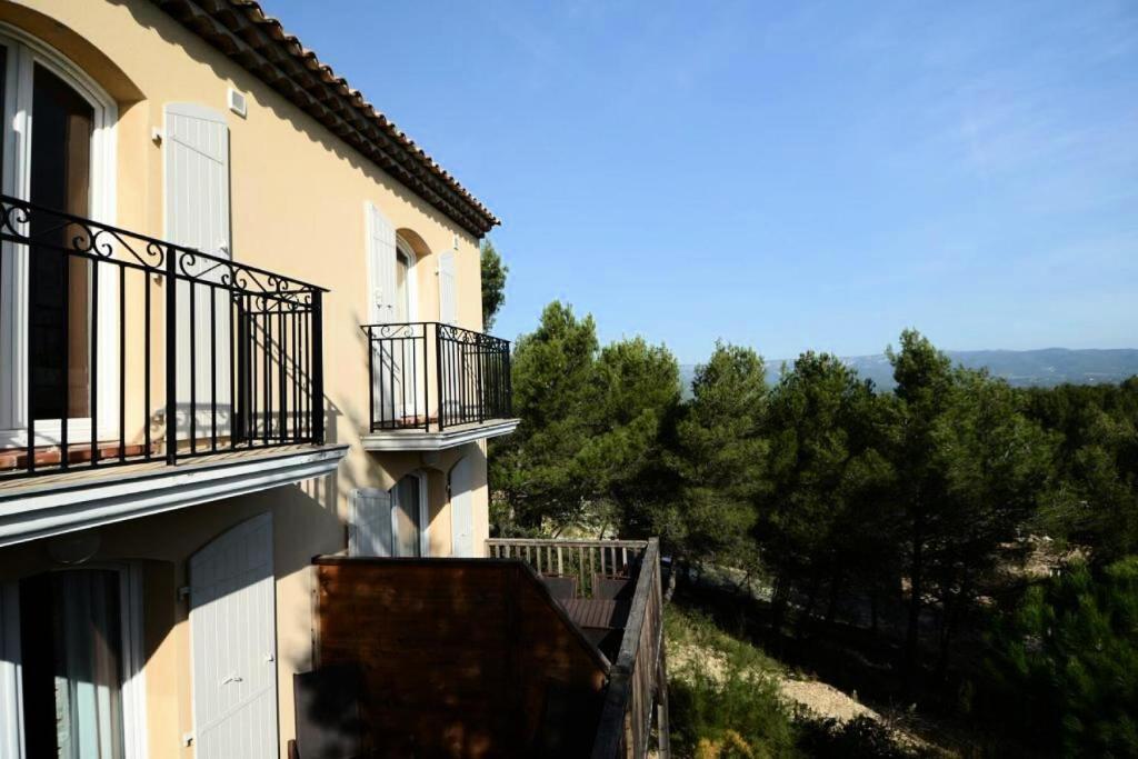 a building with balconies and a view of trees at Les Coteaux de Pont Royal en Provence - maeva Home - Appartement 3 pièces 6 214 in Mallemort