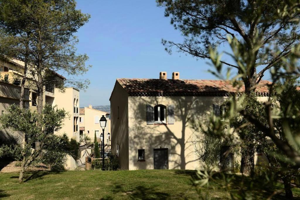 a large white building with trees in the foreground at Les Coteaux de Pont Royal en Provence - maeva Home - Appartement 3 pièces 6 214 in Mallemort