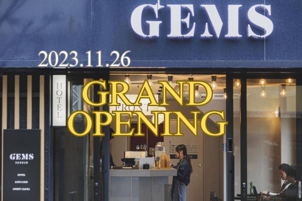 a man standing in front of a grand firm opening sign at GEMS YUFUIN Hotel and Spa Cafe Bar in Yufu