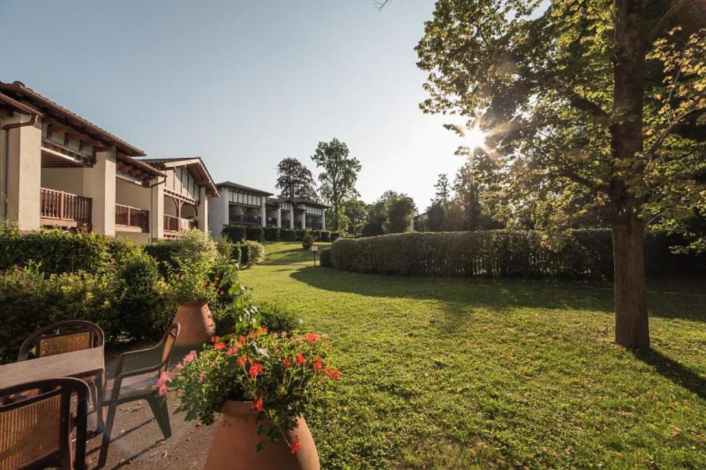 a garden with two benches and flowers in a yard at Résidence Le Parc d&#39;Arradoy - maeva Home - Appartement 3 pièces 6 personne 254 in Uhart-Cize