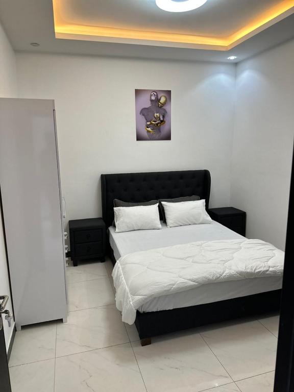 Schlafzimmer mit einem Bett mit einem schwarzen Kopfteil in der Unterkunft Studio meublé calme et cosy in Dakar
