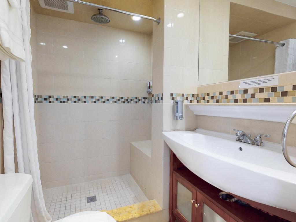 a bathroom with a sink and a tub and a shower at The Grand Resort and Spa & Worthington All Male in Fort Lauderdale