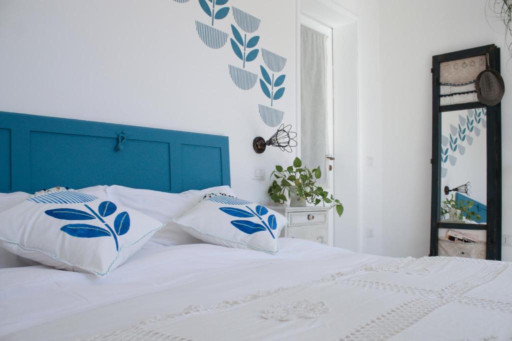 Una cama blanca con almohadas azules y blancas. en Buen Aire, en Cagliari