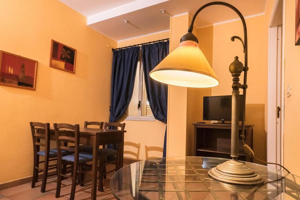 シラクーサにあるLife Hotels Residence dei Baroniのダイニングルーム(ガラステーブル、ランプ付)