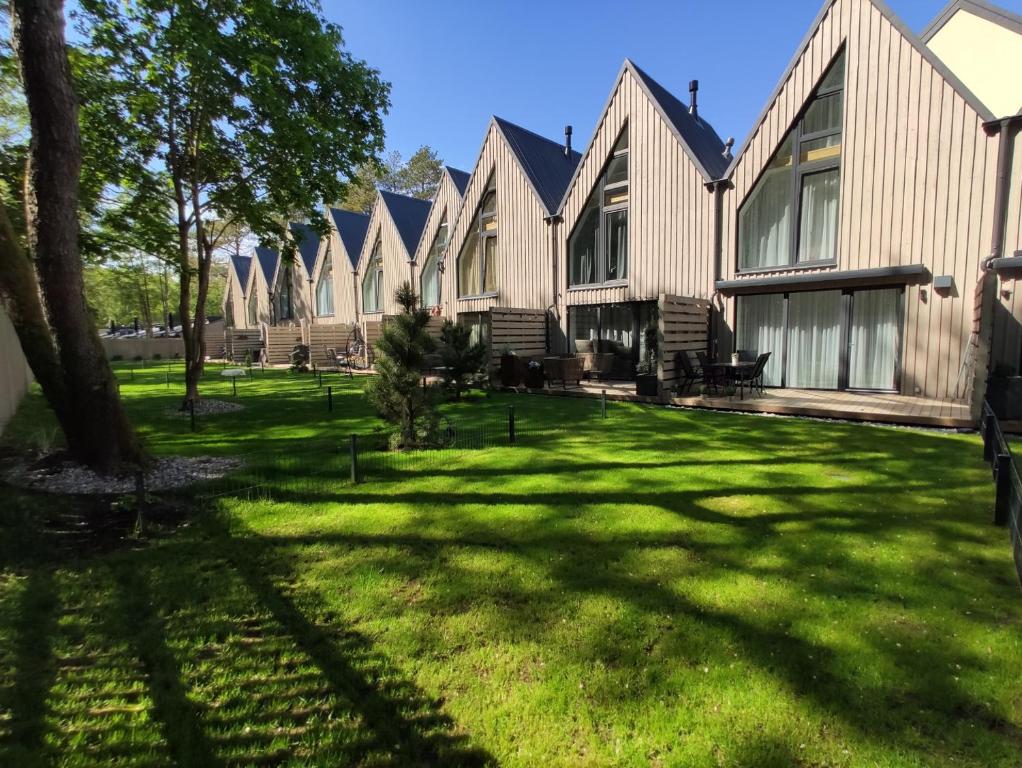 a row of houses on a green lawn at Villa Butterfly in Palanga