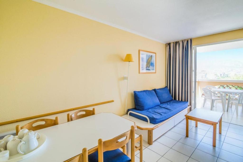 un salon avec un canapé bleu et une table dans l'établissement Résidence le Hameau de Cap Esterel - maeva Home - Appartement 2 pièces 5 personnes - Confort MAE-5041, à Saint-Raphaël