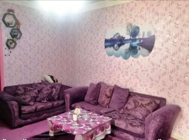 - un salon avec un canapé violet et une table dans l'établissement شقق فندقيه مفروشه شامل الما الكهرباء, à Irbid