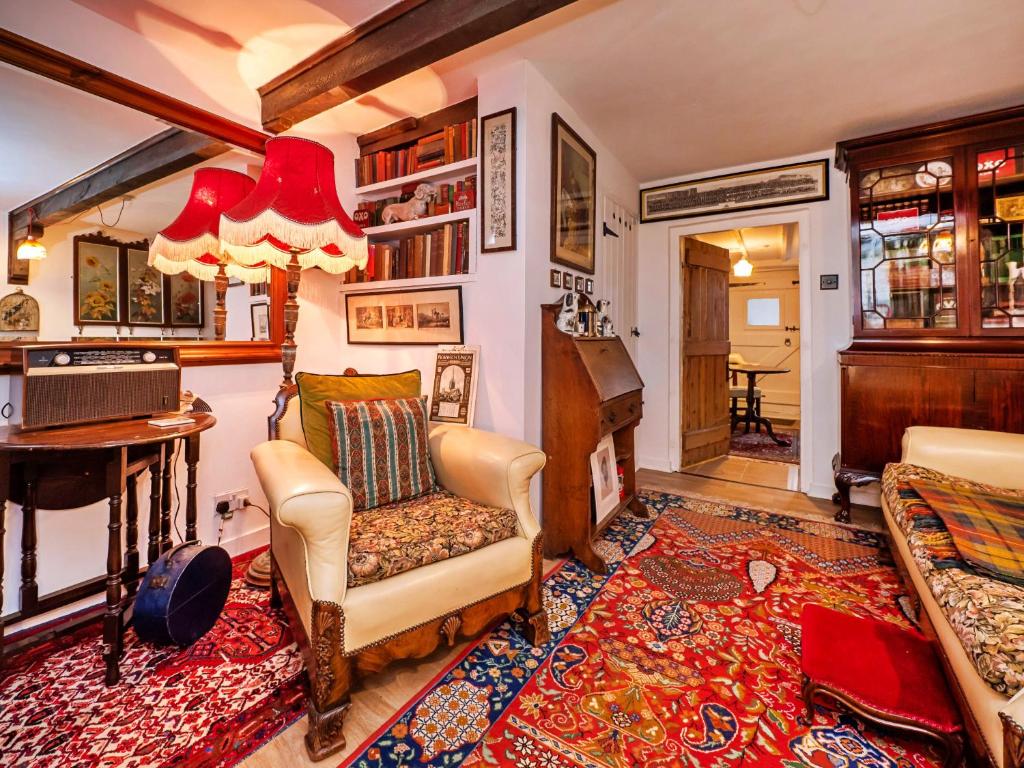 - un salon avec une chaise et un piano dans l'établissement Finest Retreats - Lychgate Cottage, à Mattishall
